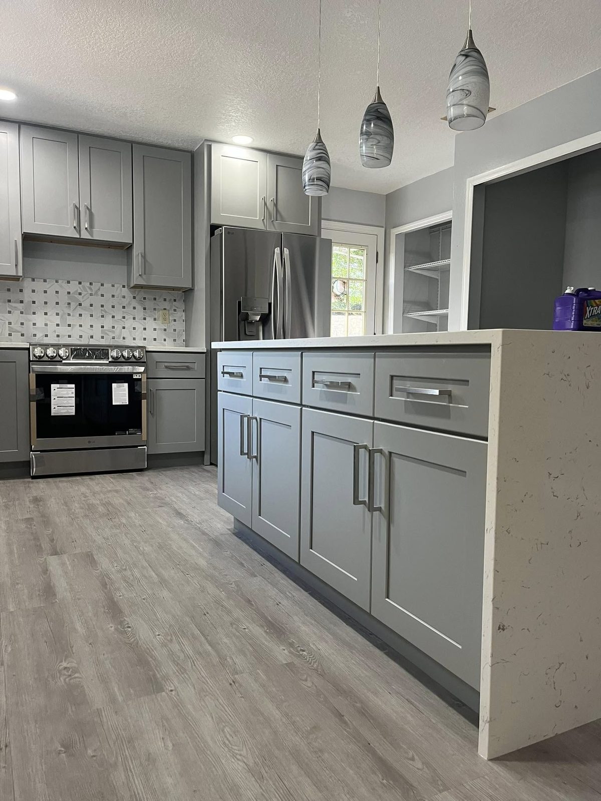 Remodeled kitchen with new cabinetry, backsplash, and stainless range